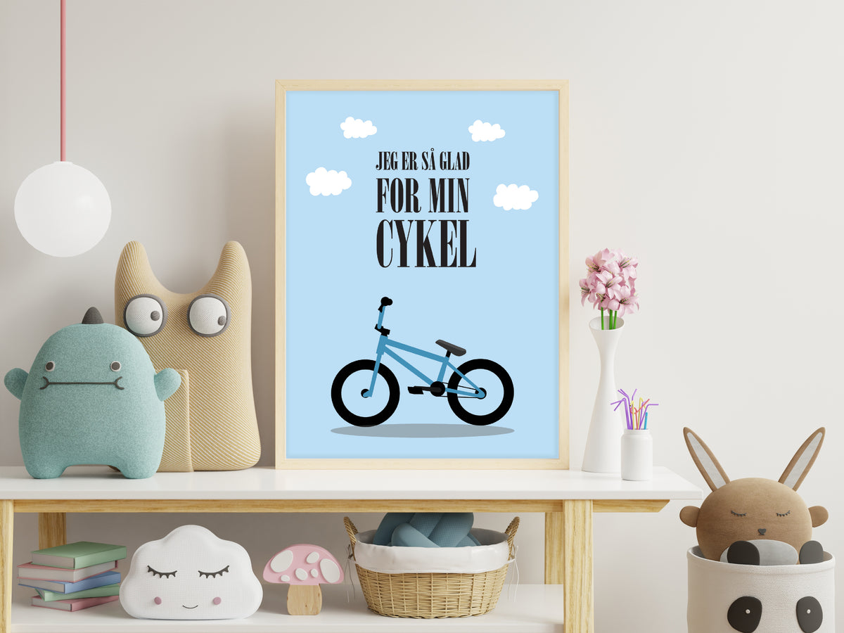 Blå børneplakat med cykelsang hængende på et lyst børneværelse